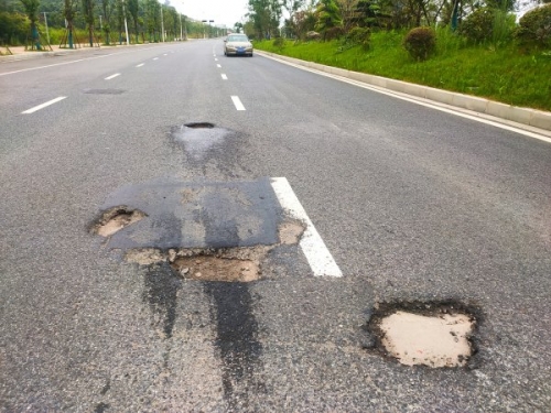 暴雨过后马路上遍地“炮弹坑” 行人车辆经过需小心